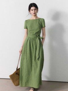 A woman wearing a sage green vertical-striped maxi dress with a tie belt.