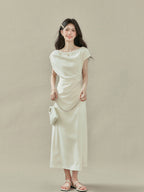 Back view of cream off-shoulder dress with short sleeves and V-neckline.