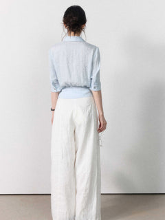 Light blue button-up blouse featuring a collar and tied belt.