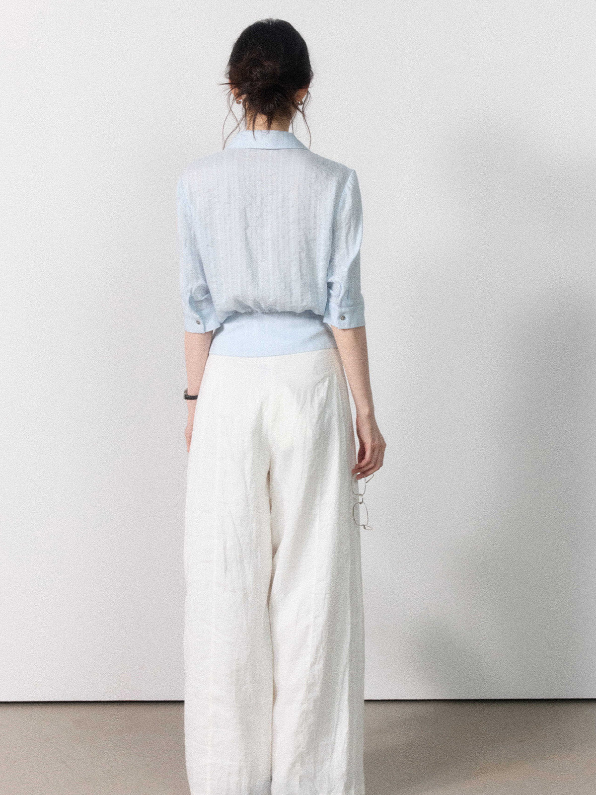 Light blue button-up blouse featuring a collar and tied belt.