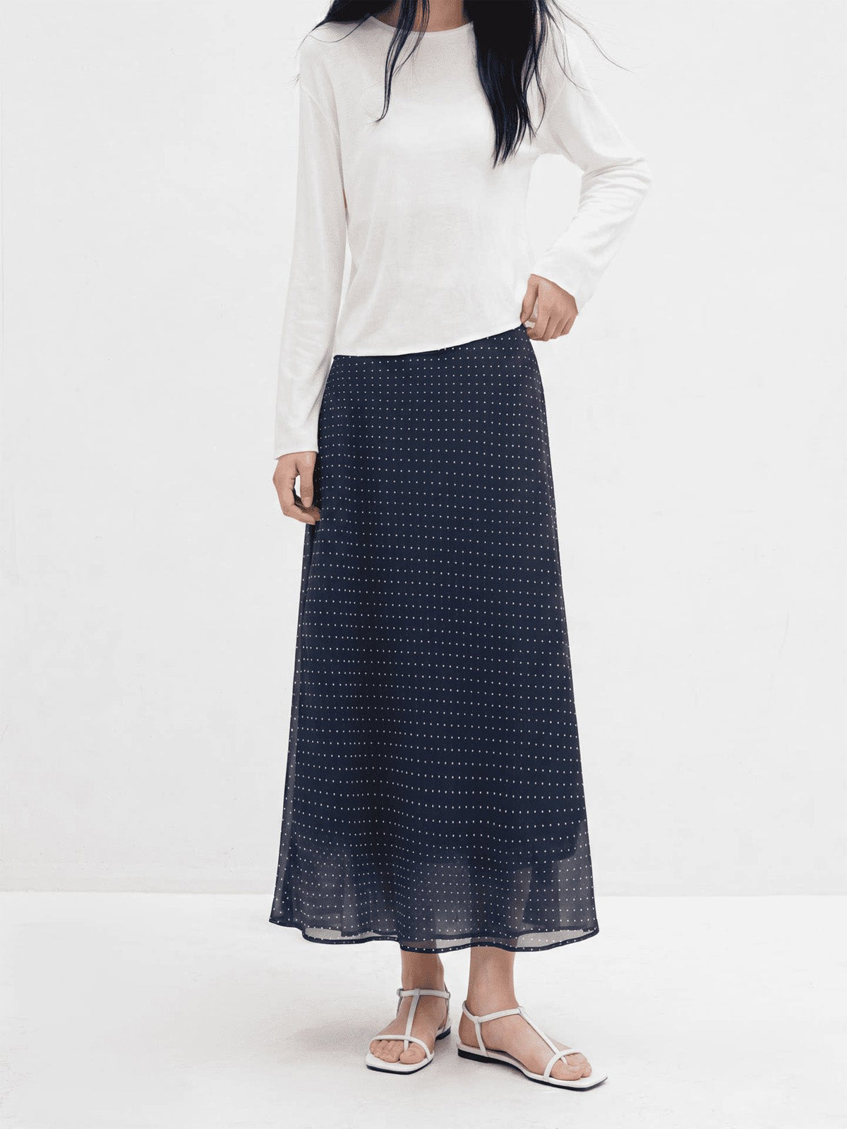 Navy polka dot A-line midi skirt with elastic waistband and flared hem.