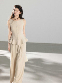 Beige high-rise wide-leg pants shown from the back with a straight hem