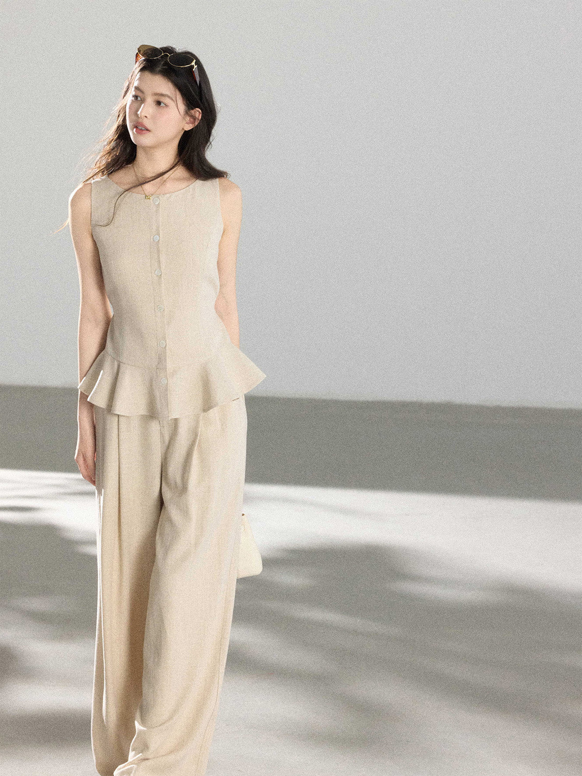 Beige high-rise wide-leg pants shown from the back with a straight hem