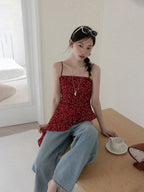 Red floral tank top shown from front, highlighting asymmetrical hemline.