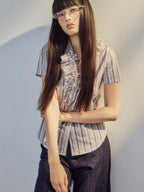 V-neck blouse with ruffled trim and button placket closure.