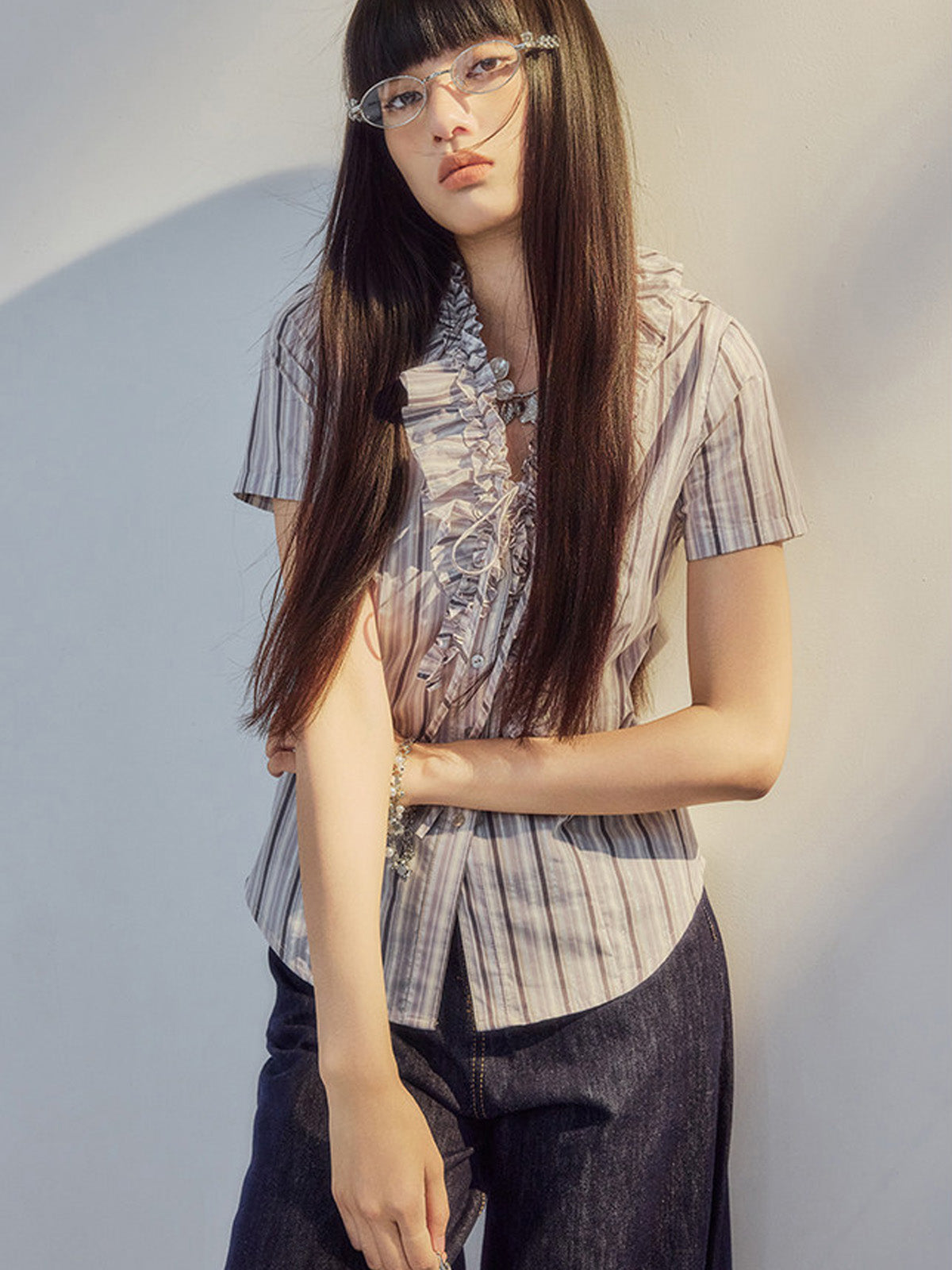 V-neck blouse with ruffled trim and button placket closure.