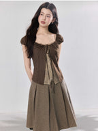 Brown puff sleeve top shown over a sheer inner layer.