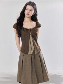 Brown puff sleeve top shown over a sheer inner layer.