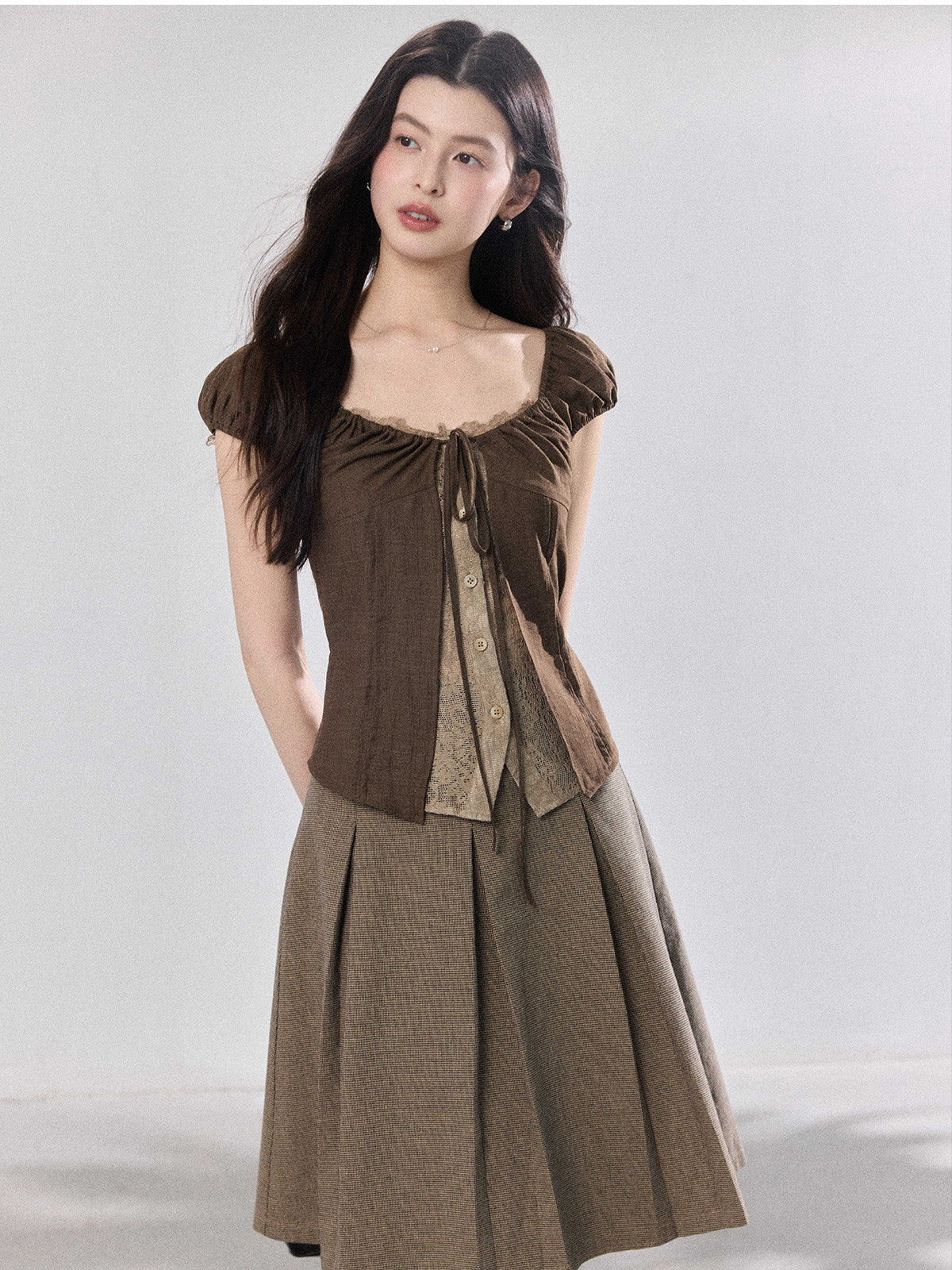 Brown puff sleeve top shown over a sheer inner layer.