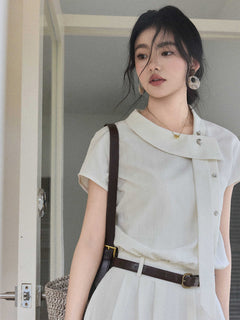 A close-up of the ivory A-line long dress featuring a diagonal placket and silver buttons.