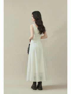 Ivory maxi dress with a straight hem, visible side pockets, and button details on the neckline.