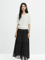 Side profile of black floral A-line skirt with sheer overlay at hem