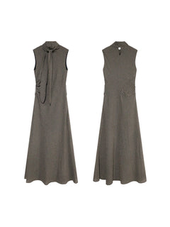 A front and back view of a sleeveless black gingham floor-length dress with a high neck and tie detail.