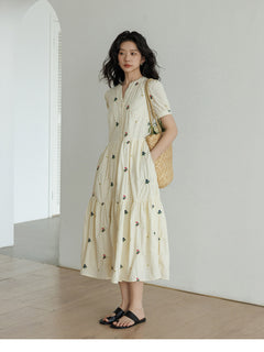 Tiered skirt dress with gathered waist and floral details.
