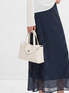 Navy polka dot A-line midi skirt shown from front with flared hem and high waist.
