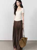 Close-up of brown wide-leg pants with vertical texture and pleats