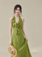 Green halter dress featuring a flared hem and floral pattern.