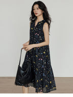 Black midi dress with tiered skirt, V-neck, and side pockets