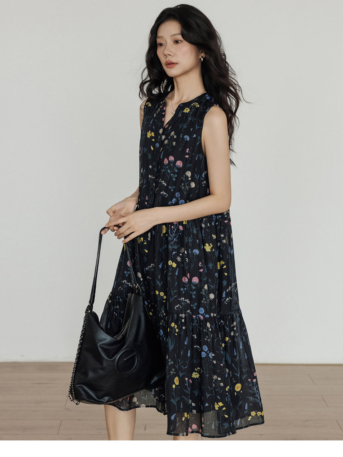 Black midi dress with tiered skirt, V-neck, and side pockets