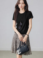 Leopard print pleated midi skirt shown in a flared style with asymmetrical hem.