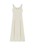 Ivory dress with a square neckline, thin straps, embroidered trim, and side pockets.