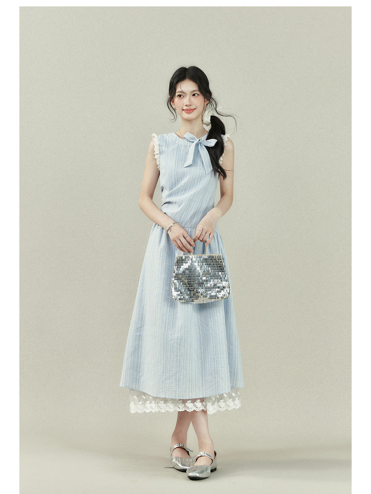 Light blue dress with vertical stripes, lace trim on the shoulders and hem, a bow tie neckline, gathered waist, and A-line silhouette.