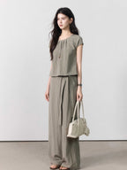 Taupe grey wide-leg pants with a straight hem, visible from the back.