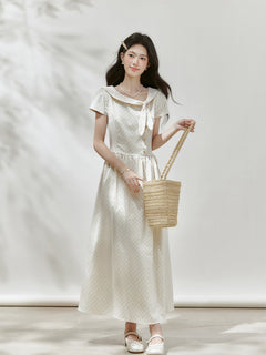 Ivory polka dot midi dress shown from the back with a gathered waist.