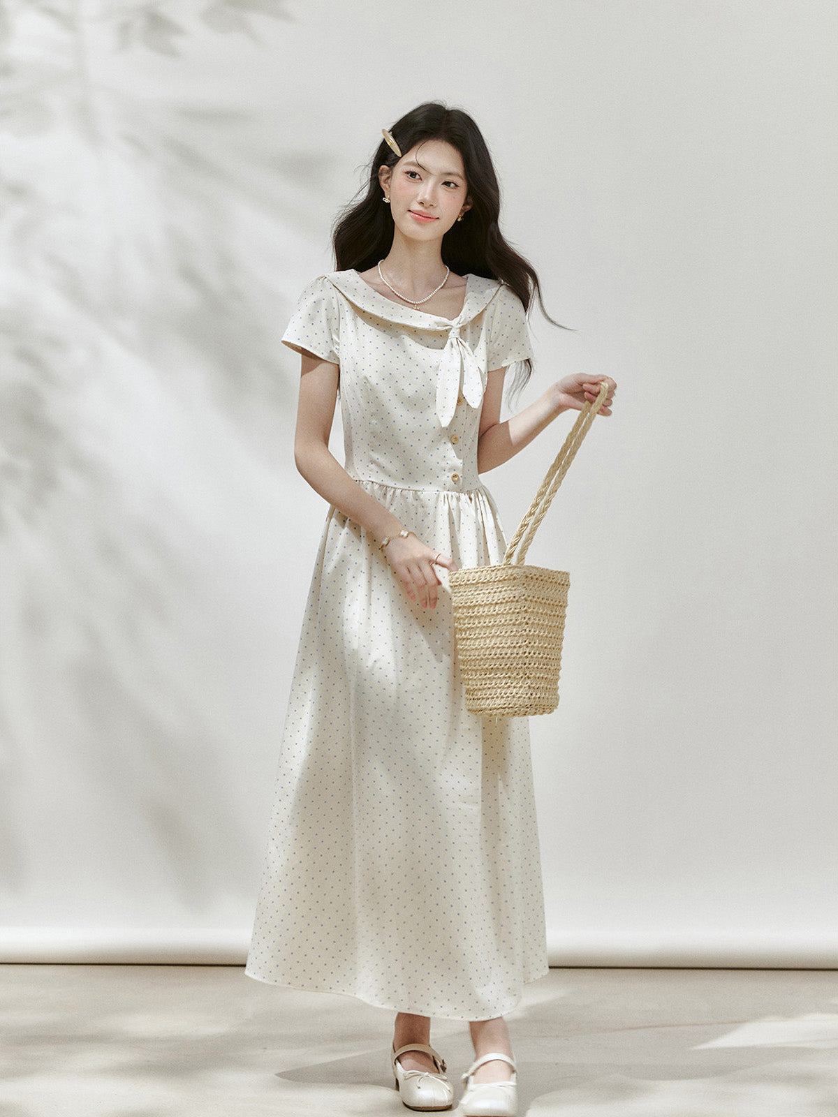 Ivory polka dot midi dress shown from the back with a gathered waist.