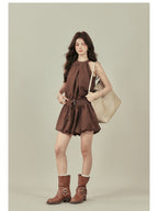 Front view of brown halter neck dress with gathered fabric at the waist.