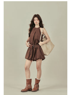 Front view of brown halter neck dress with gathered fabric at the waist.