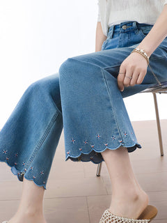 Close-up of back pockets and waistband label on light blue flared jeans.