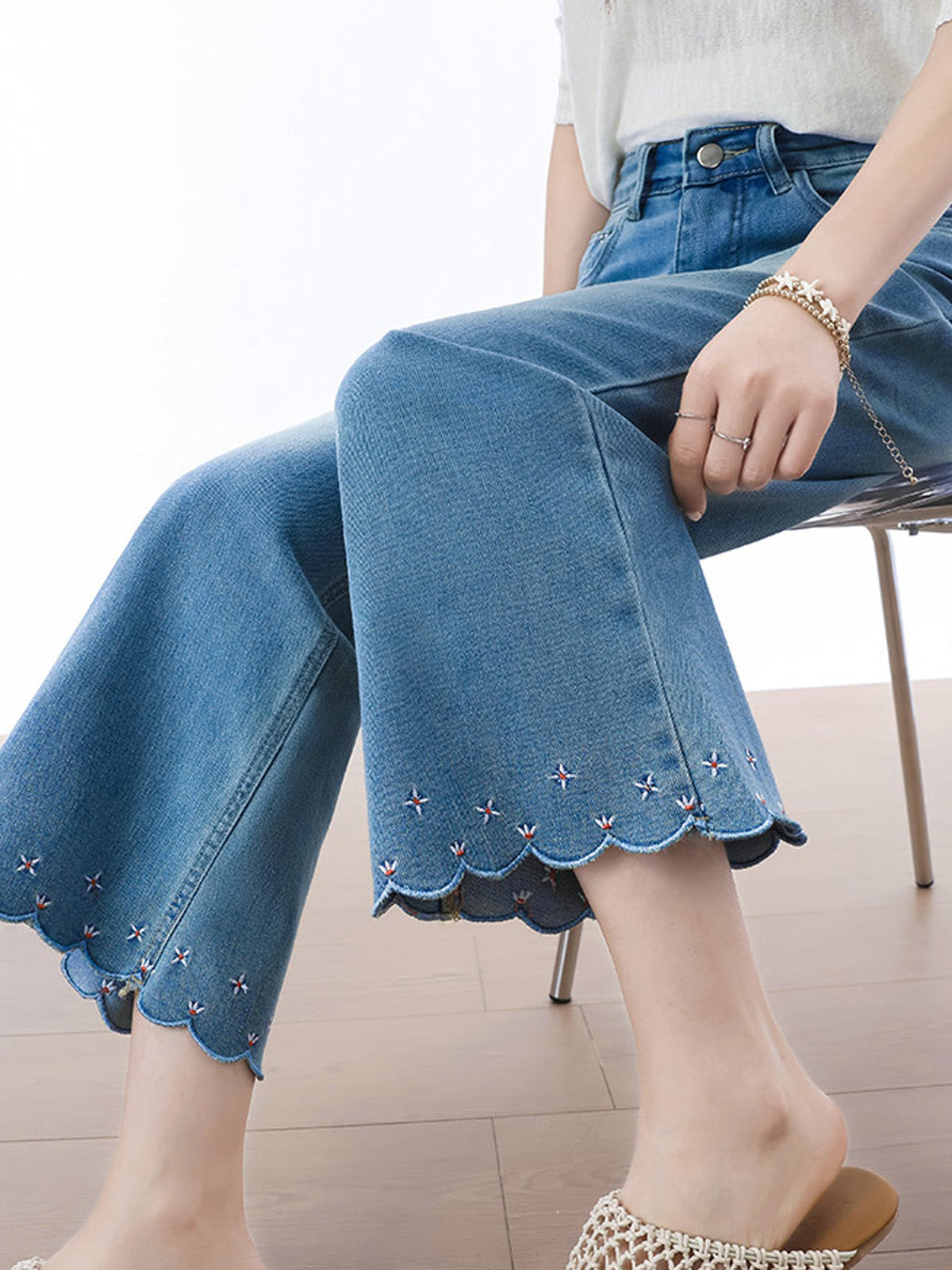 Close-up of back pockets and waistband label on light blue flared jeans.