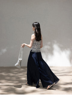 Blue floral camisole worn with dark pants and woven bag