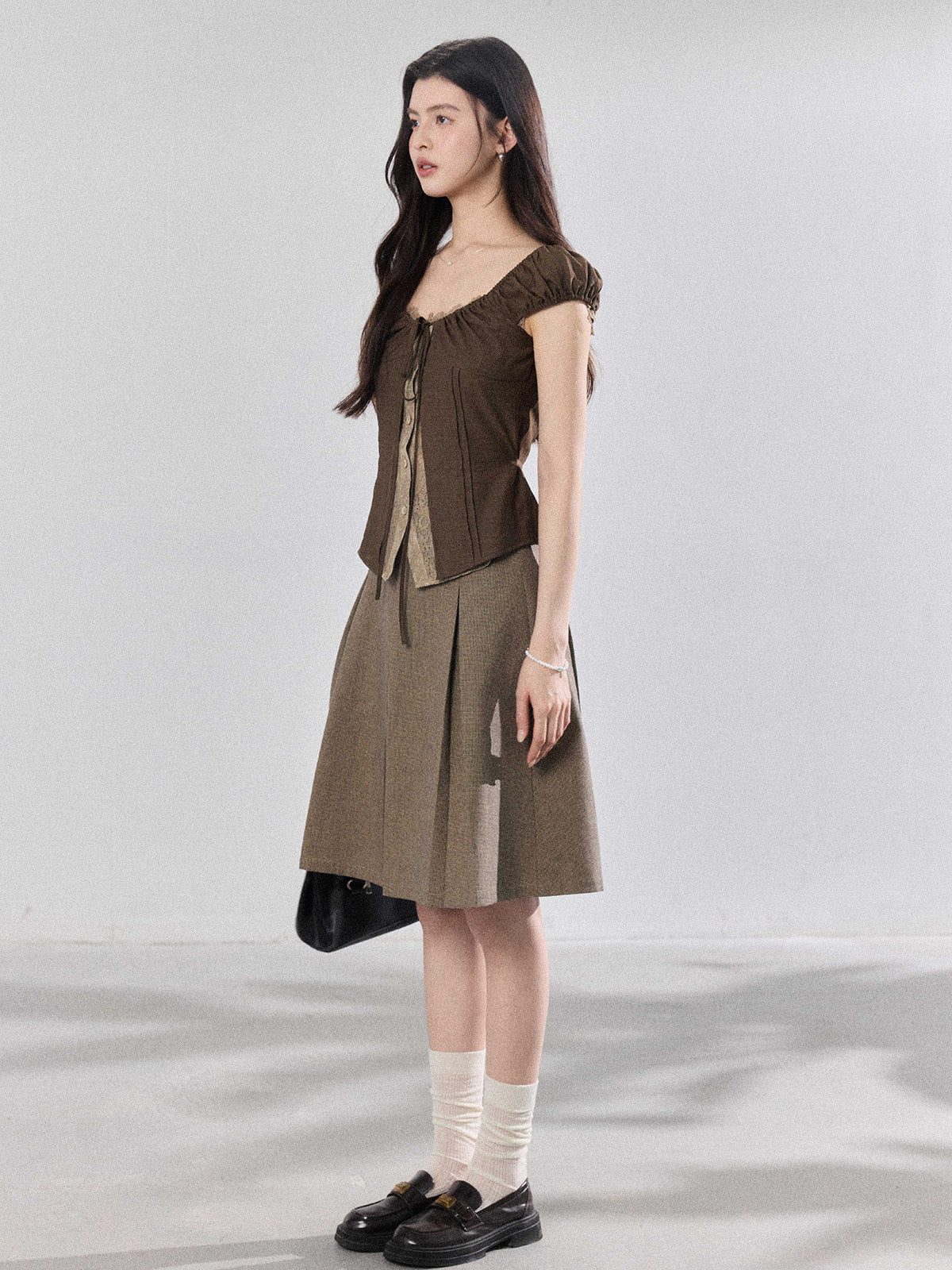 Side view of a model wearing the brown puff sleeve top.