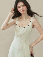 Ivory maxi dress with a square neckline, thin straps, and embroidered trim on the neckline.