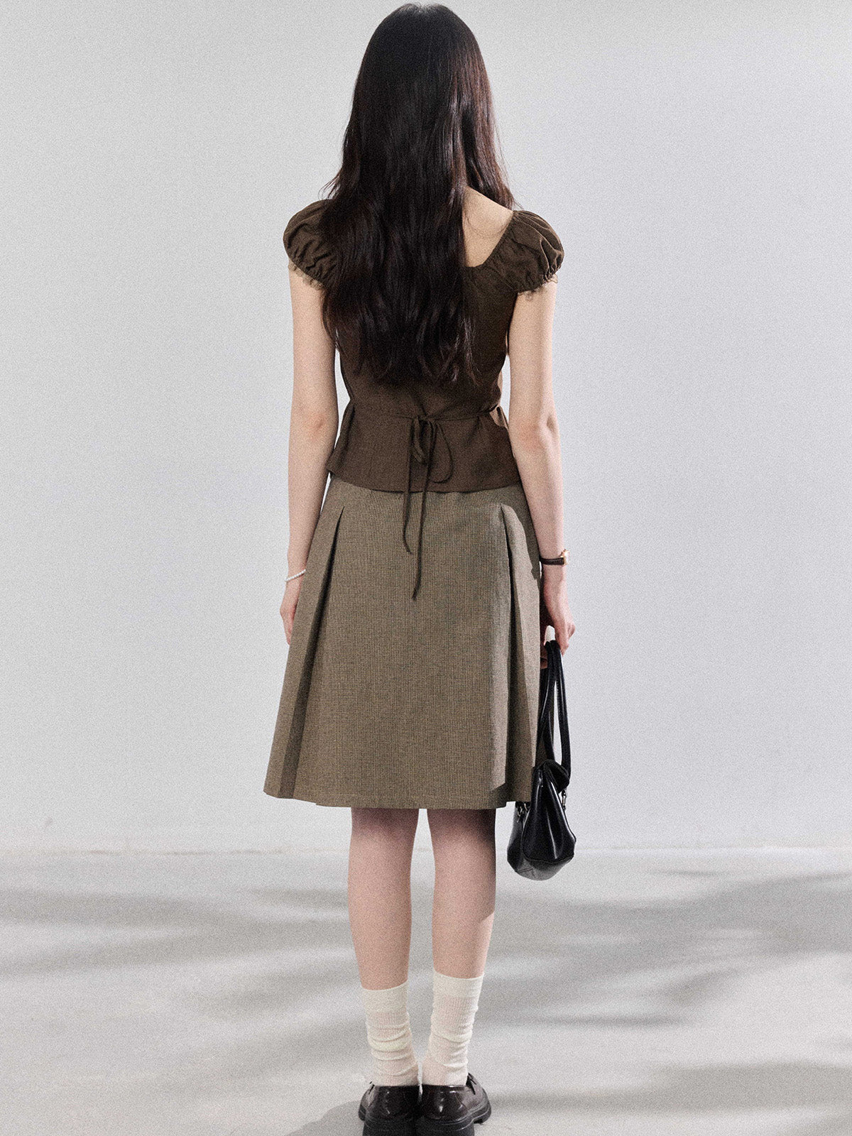 Back view showing the tie-waist detail of the brown top.