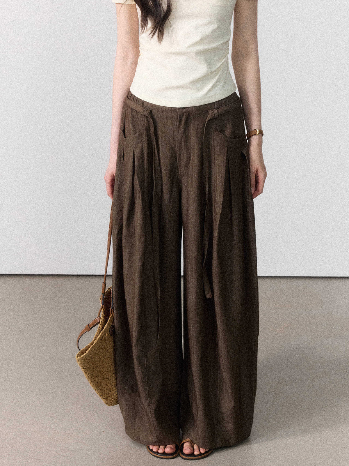 Brown wide-leg pants with a high-rise waist and side pleats