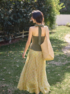 Yellow plaid long skirt flowing in sunlight on grass