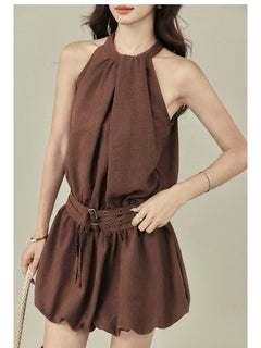 Brown sleeveless dress with pleated skirt and attached belt detail.
