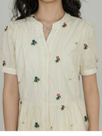 Side pockets visible on an A-line dress with floral embroidery.