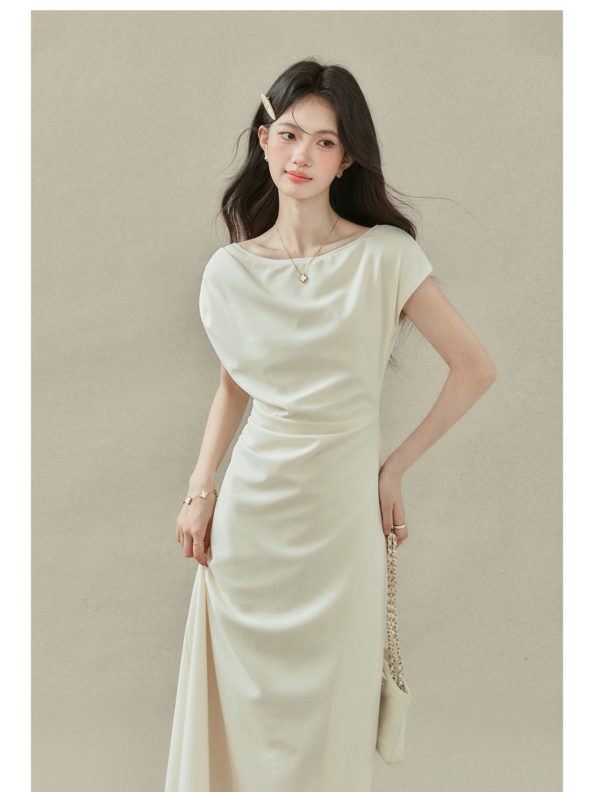 Close-up of cream off-shoulder dress with short sleeves and draped neckline.