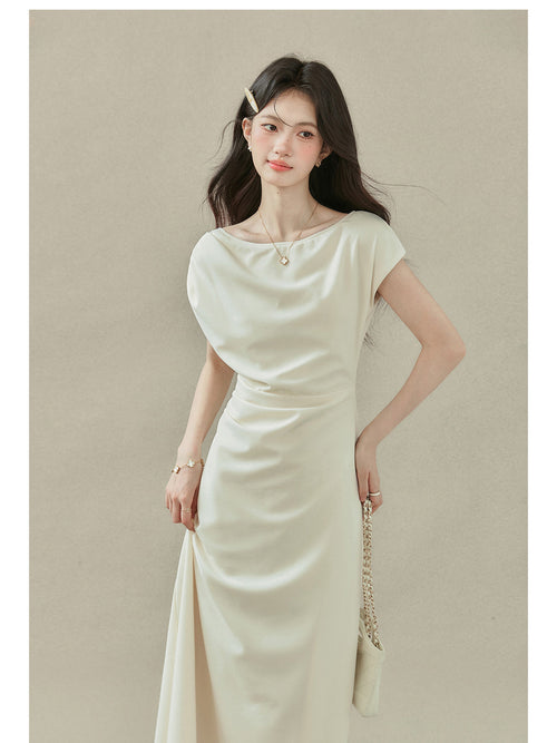 Close-up of cream off-shoulder dress with short sleeves and draped neckline.