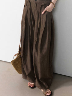 Brown wide-leg pants with a tie belt and front pockets