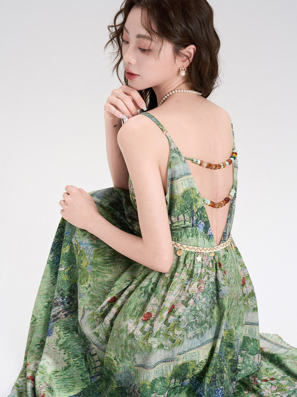 Front view of green floral dress featuring a bow at the waist.