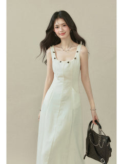 Ivory sleeveless dress with a straight hem, side pockets, and button details on the neckline.