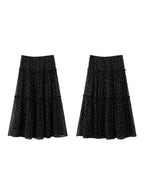 Front view of black floral skirt featuring small white print on sheer overlay