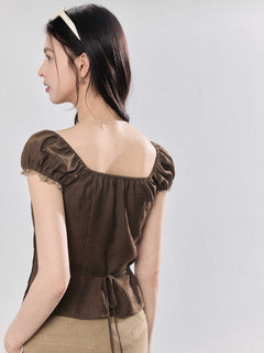 Brown puff sleeve top with lace trim visible from the back.